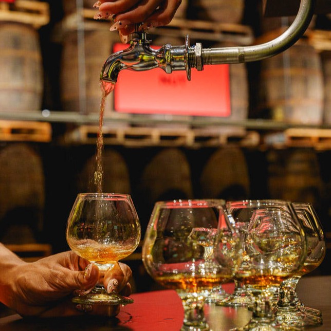 Pouring from a Casa BACARDÍ aged rum barrel.